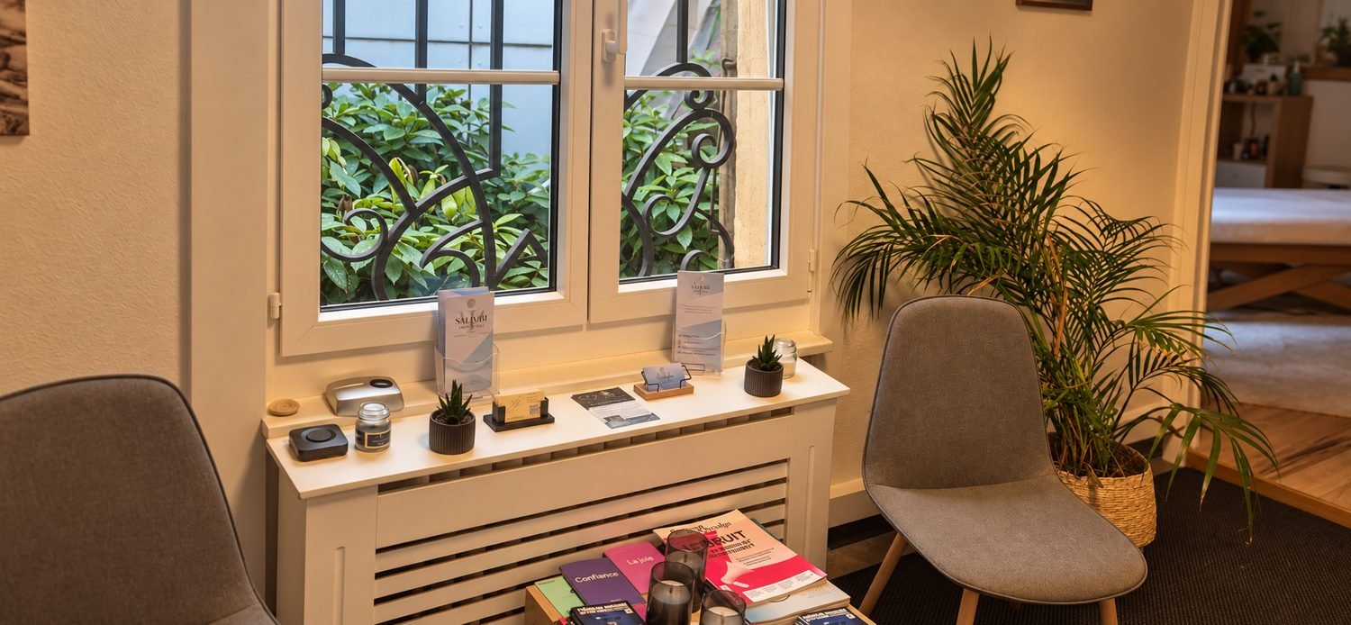 Salle d'attente : chaises, plante, brochures près de la fenêtre