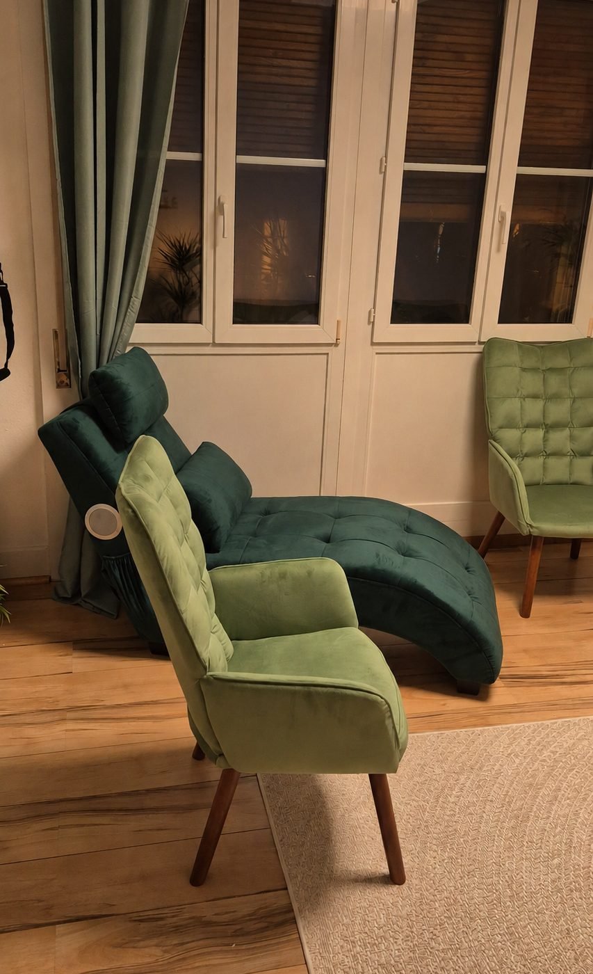 Méridienne verte et fauteuil devant les fenêtres